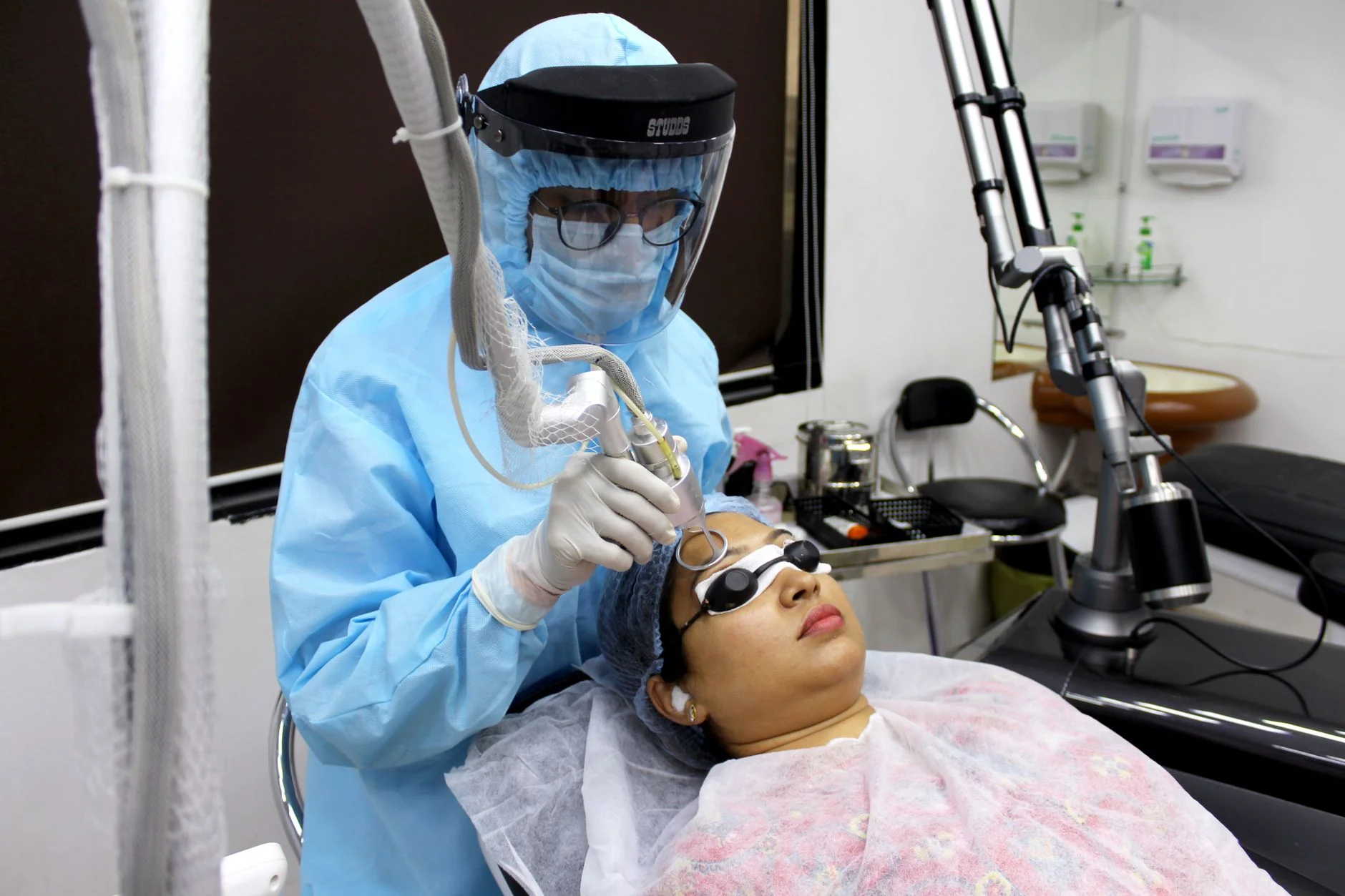 A medical practitioner performs laser treatment on a woman for skin care. at House of Aetheria, Gurugram