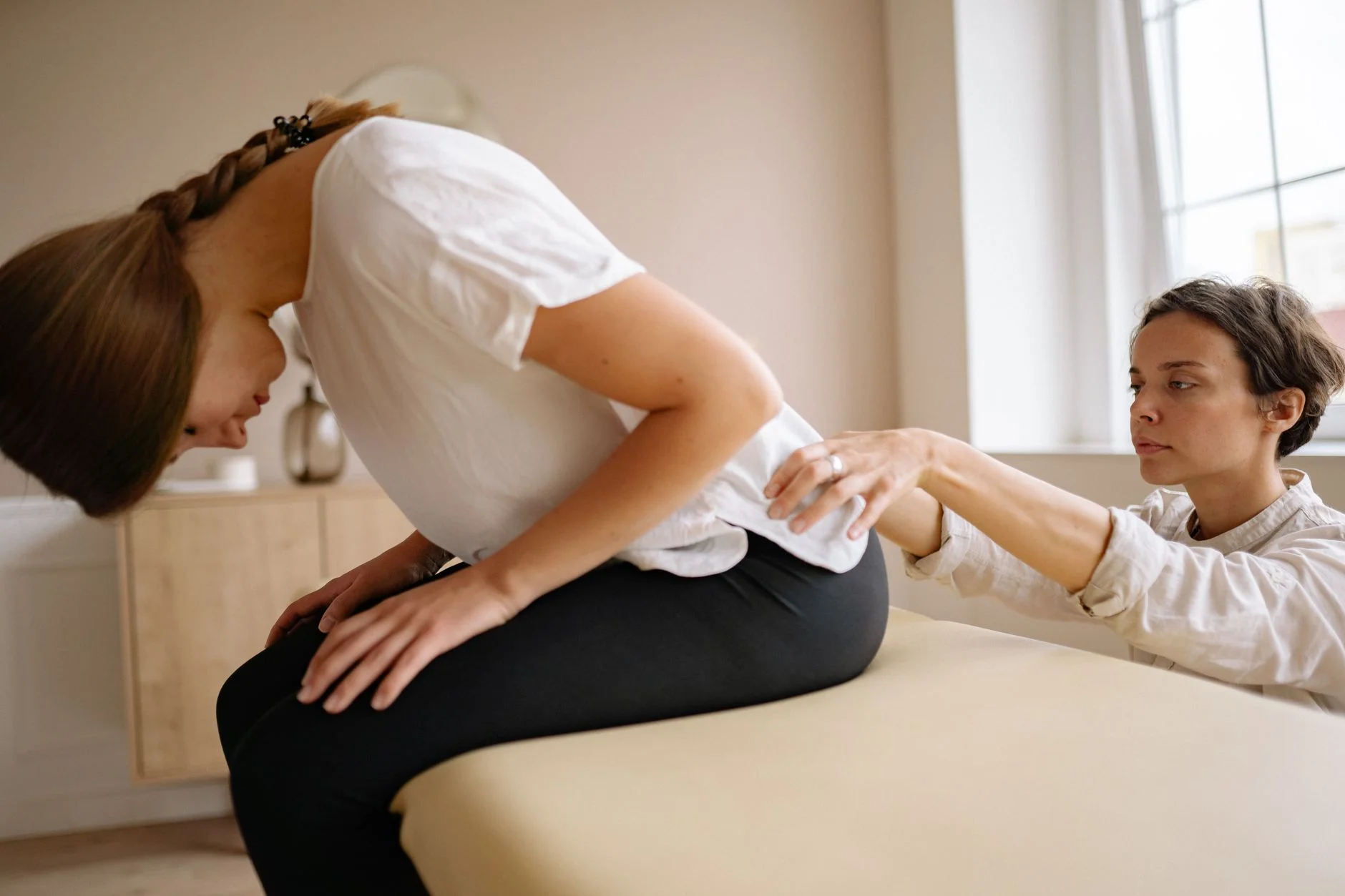 A therapist stretches a patient's back during a physical therapy session indoors. at House of Aetheria, Gurugram