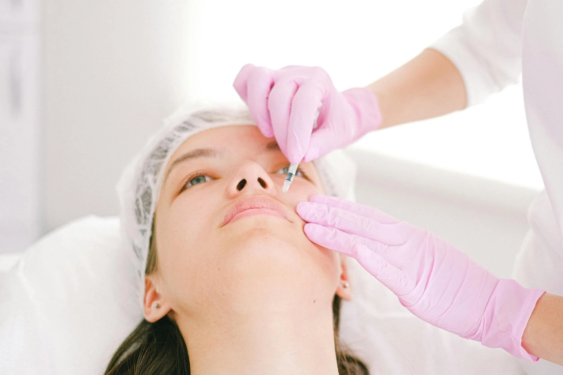 Woman receiving a facial cosmetic injection in a professional clinic setting. at House of Aetheria, Gurugram