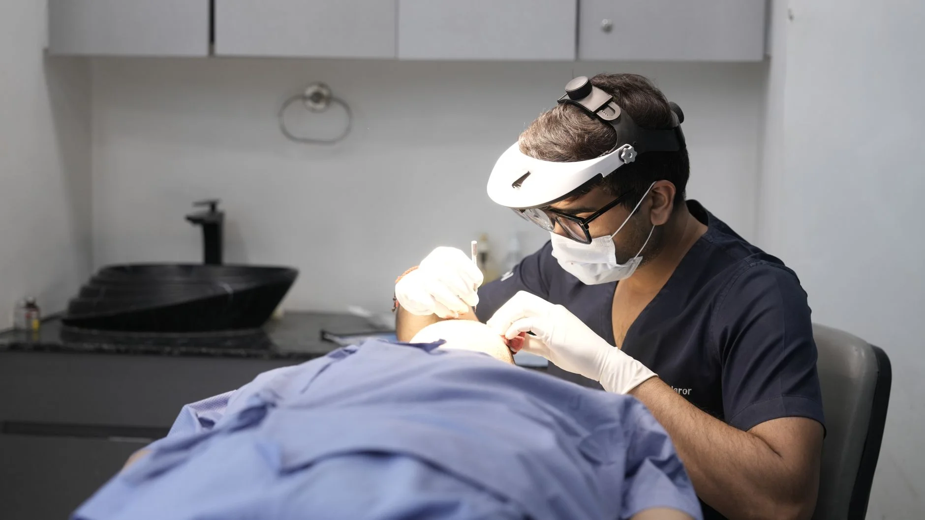A dermatologist conducts a skin treatment on a patient in a modern clinic setting. at House of Aetheria, Gurugram