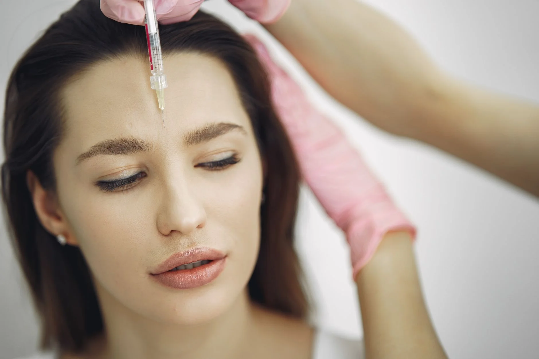 Close-up of facial treatment with injection in a spa setting, focusing on the forehead. at House of Aetheria, Gurugram