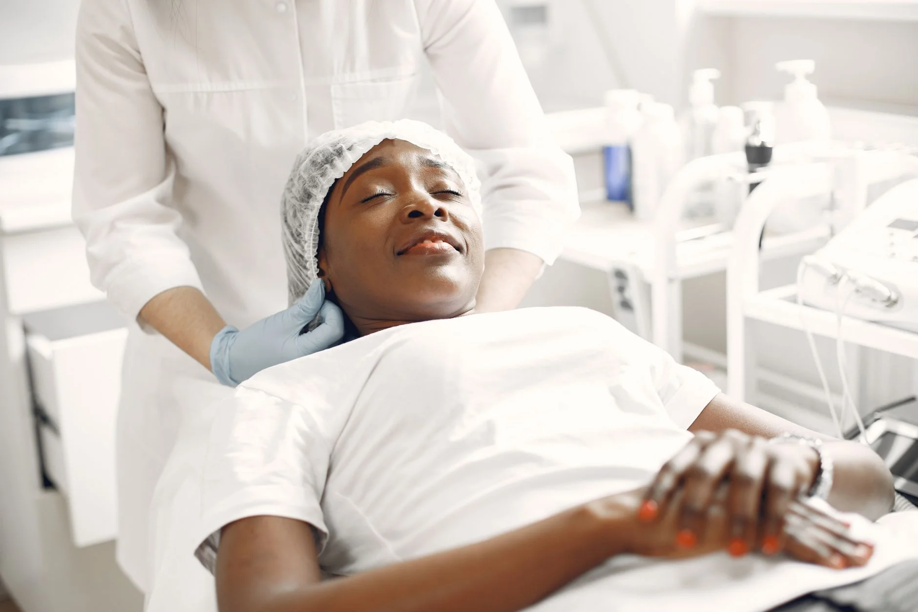 A woman enjoying a relaxing facial massage in a modern aesthetic clinic setting. at House of Aetheria, Gurugram